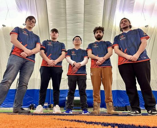 Members of the 2023 Esports Finals Team stands with arms resting in front.